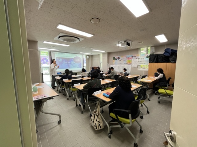 주민배움터 시즌2교육문화분과 뇌파찍고 힐링해요 1차 참여자들이 빔프로젝트를 통해 한 남성의 연설을 듣고있다