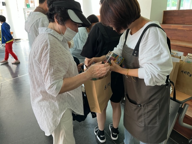 주민배움터 시즌2교육문화분과 뇌파찍고 힐링해요 2차 사업 참여자들에게 참여 증정품을 전달하고 있는 모습