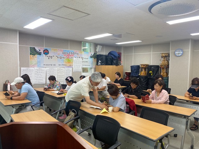 우리마을 사진 달인을 찾아라!기획홍보분과 사진달인을 찾아라 2차 강의에서 강사가 여성 참여자에게 상세 설명을 해주고 있는 모습