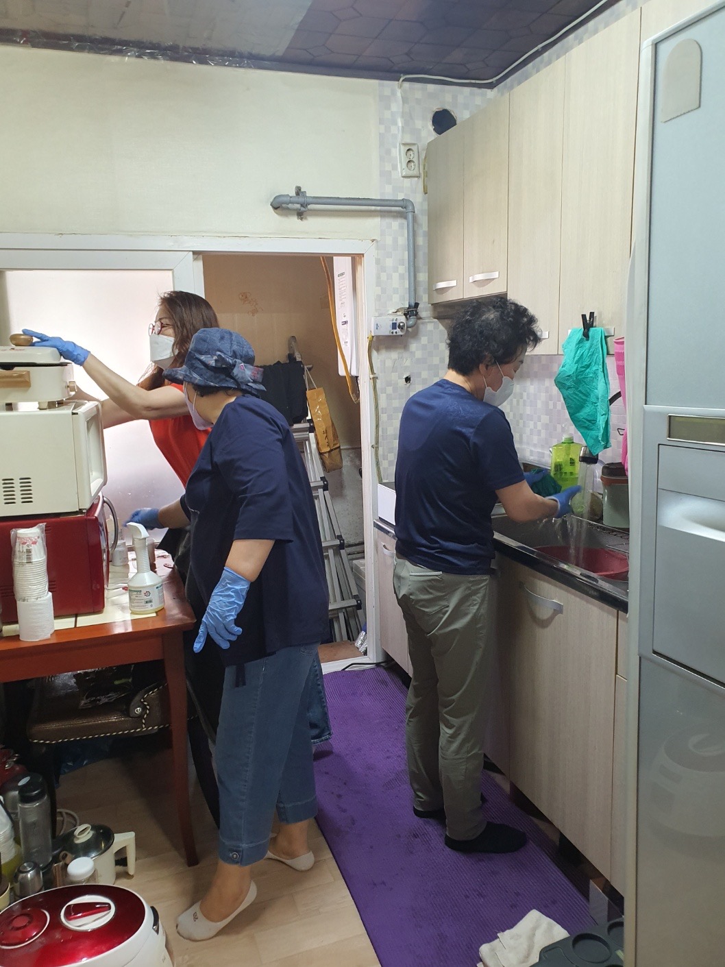 치매예방을 위한 원예치료 및 정리수납 봉사독거노인을 위한 정리수납 봉사자들이 주방을 정리하고 있는 모습