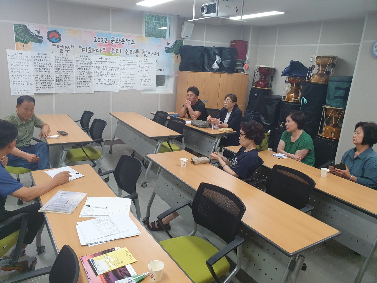 기획홍보분과회의 2022문화충전소 얼쑤 지화자 우리 소리를 찾아서 포스터가 붙고 장구가 놓여진 공간에서 참석자들이 회의를 하고있다