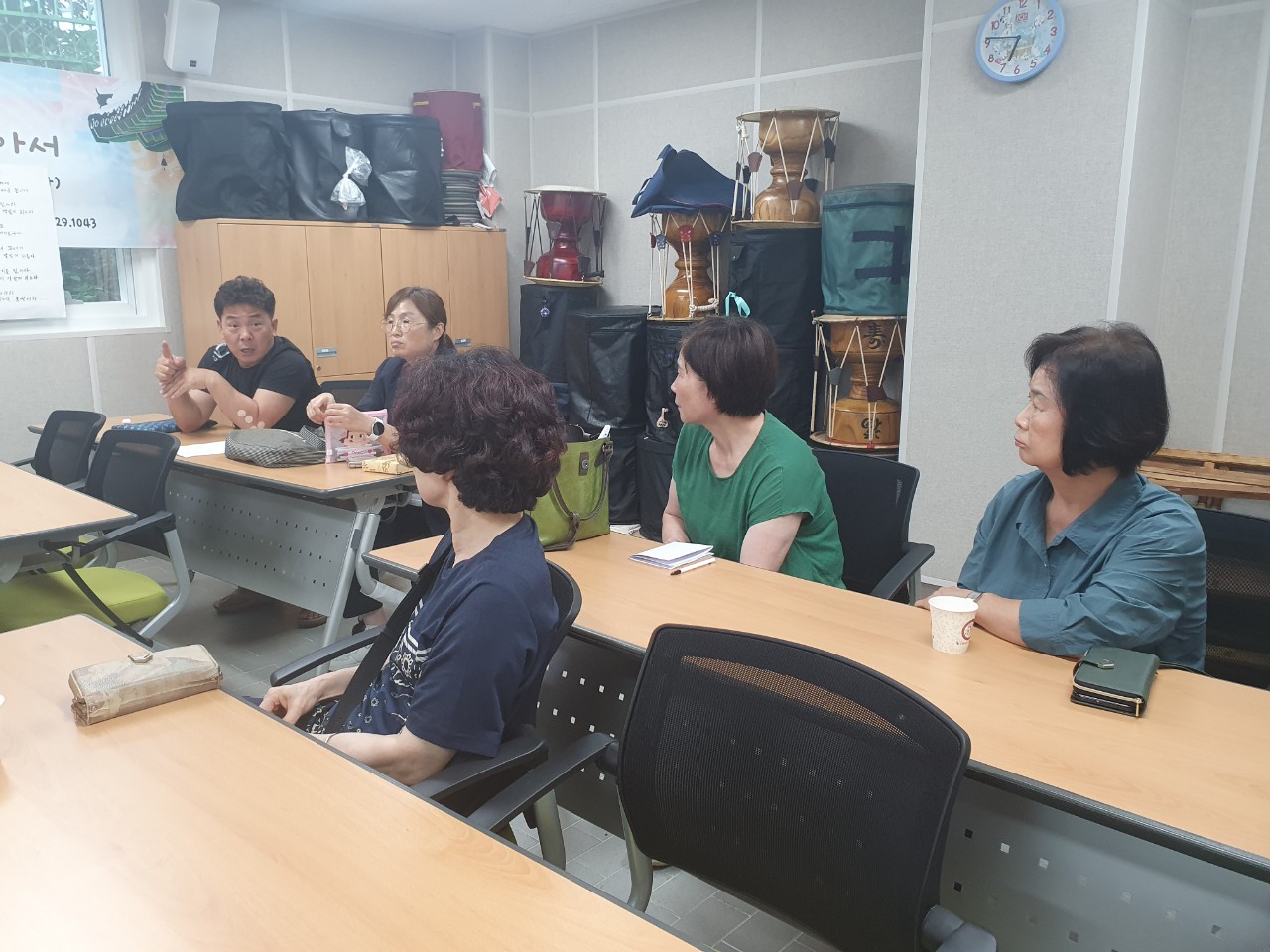 기획홍보분과회의 남성참석자가 자리에 앉아 의견을 내고 다른 참석자들이 해당 참석자를 바라보고있다