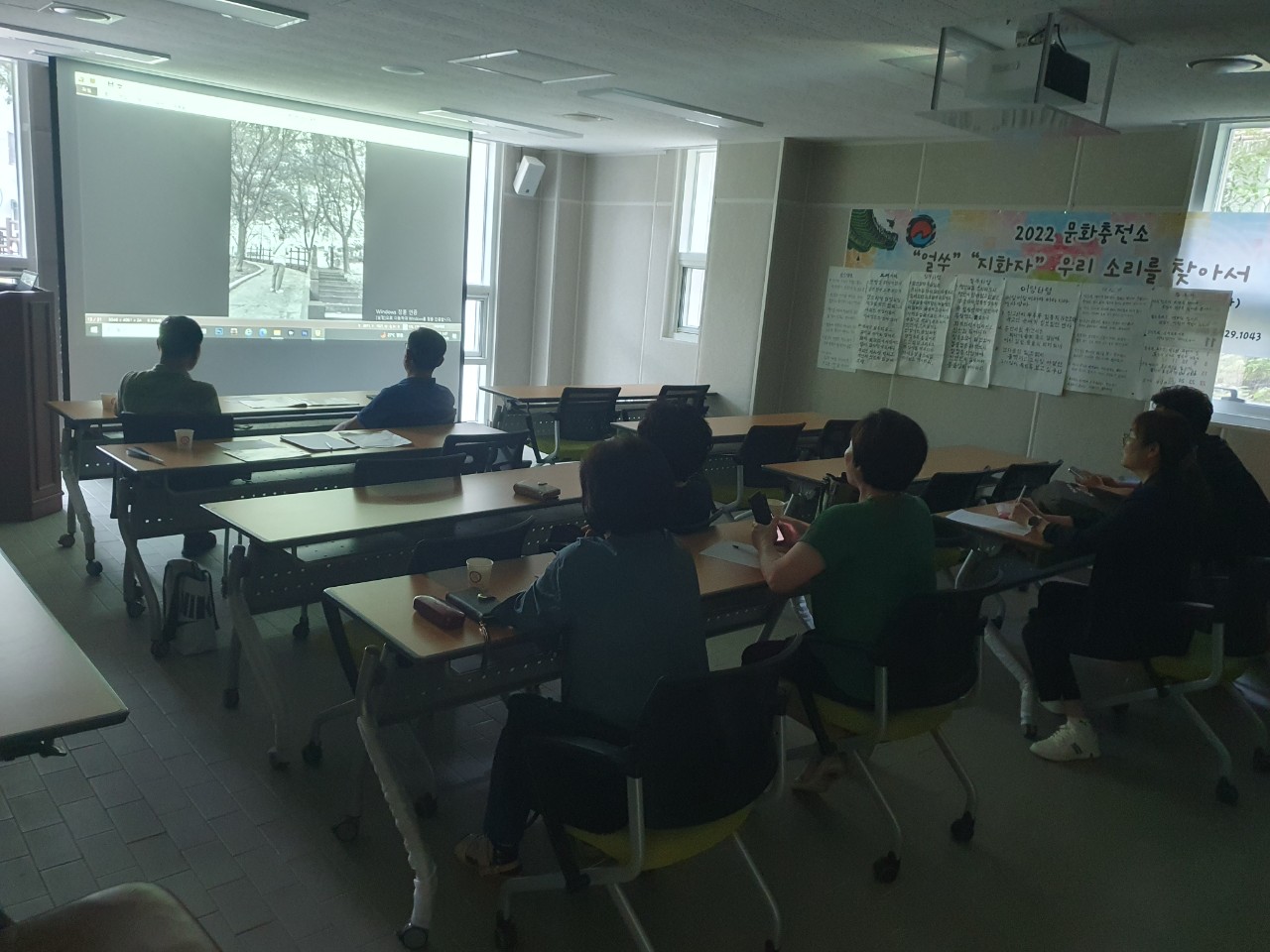 기획홍보분과회의 참석자들이 정면에있는 스크린에 나오는 화면을 바라보고 있는 현장 모습