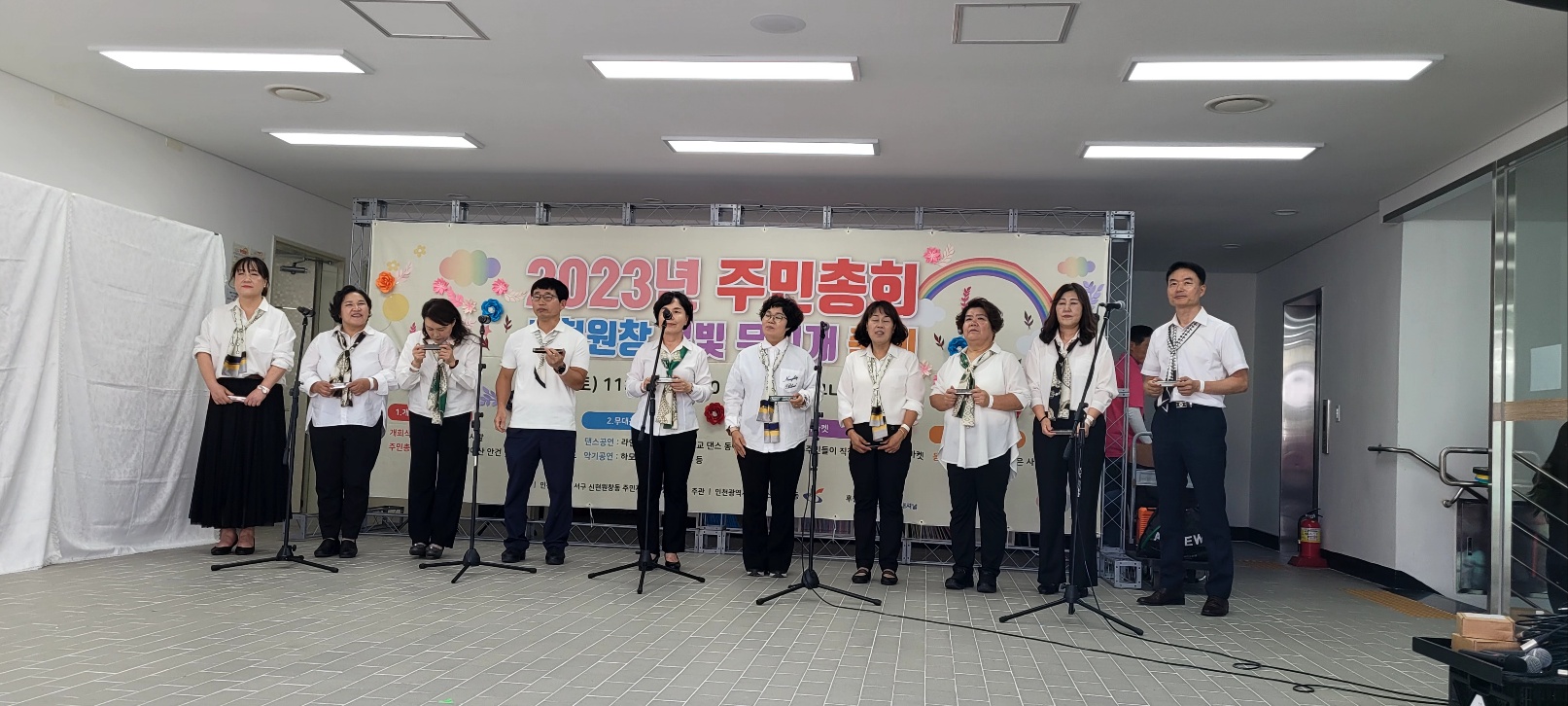 2023년 별빛 무지개 축제에 참여한 하모니카 팀이 나란히 서서 하모니카를 연주하고 있다