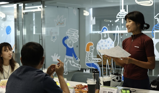 중년의 두 여성과 젊은 남성이 테이블에 앉아 대화를 하고 있는 모습