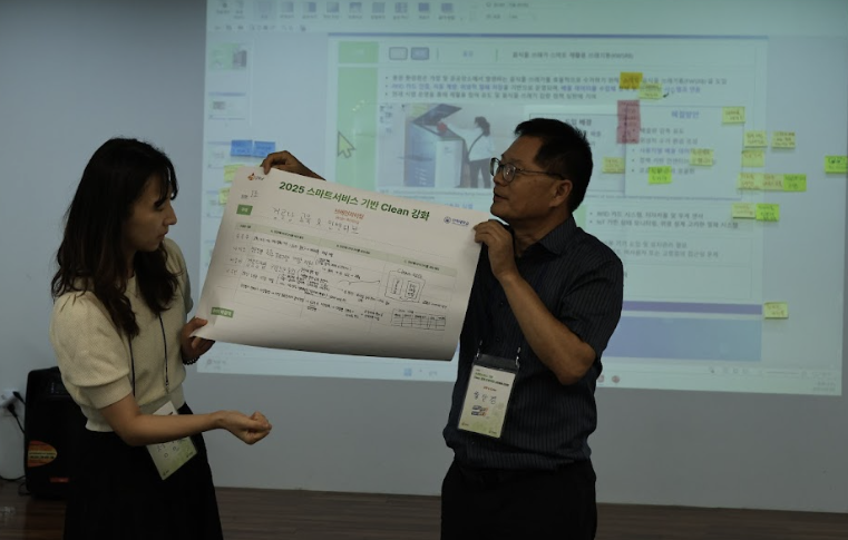 진행자가 한 테이블에서 참석자들에게 무언가를 설명하고 있는 모습