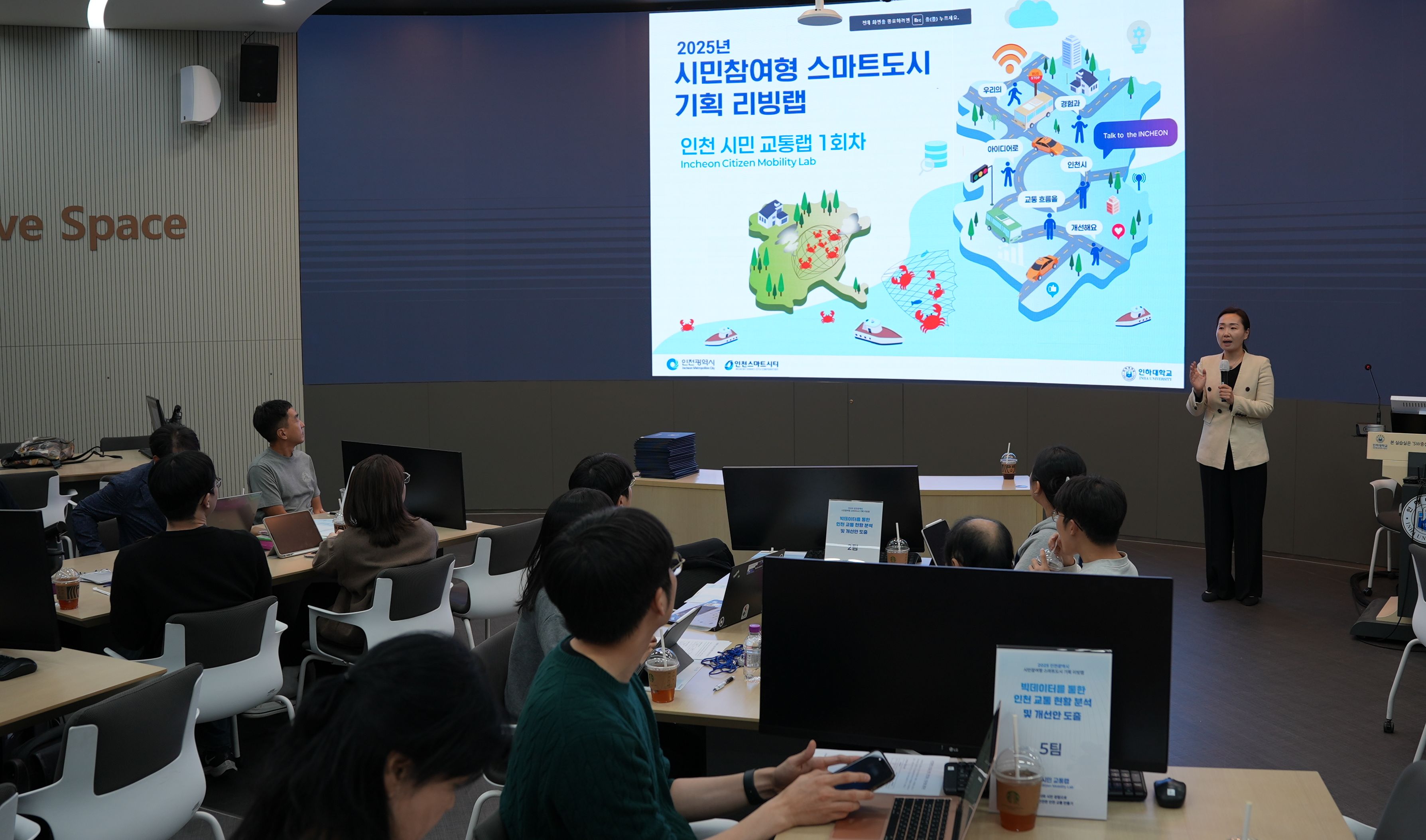 시민참여형 스마트도시 기획 리빙랩이라는 제목이 적힌 프레젠테이션 앞에서 설명하고 있는 여성 진행자의 모습