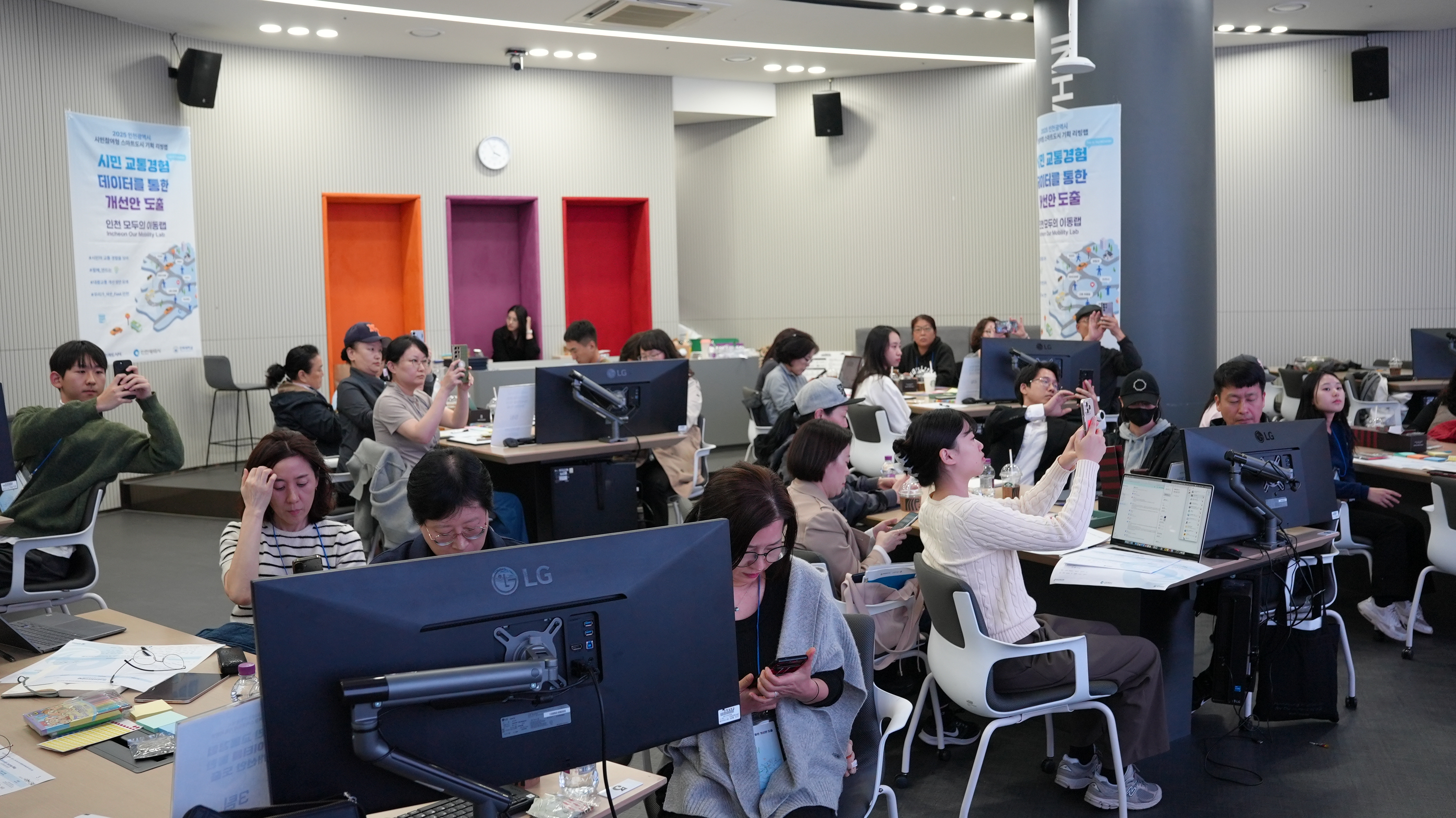 프레젠테이션 내용의 사진을 찍거나 열심히 경청하는 참석자들의 모습